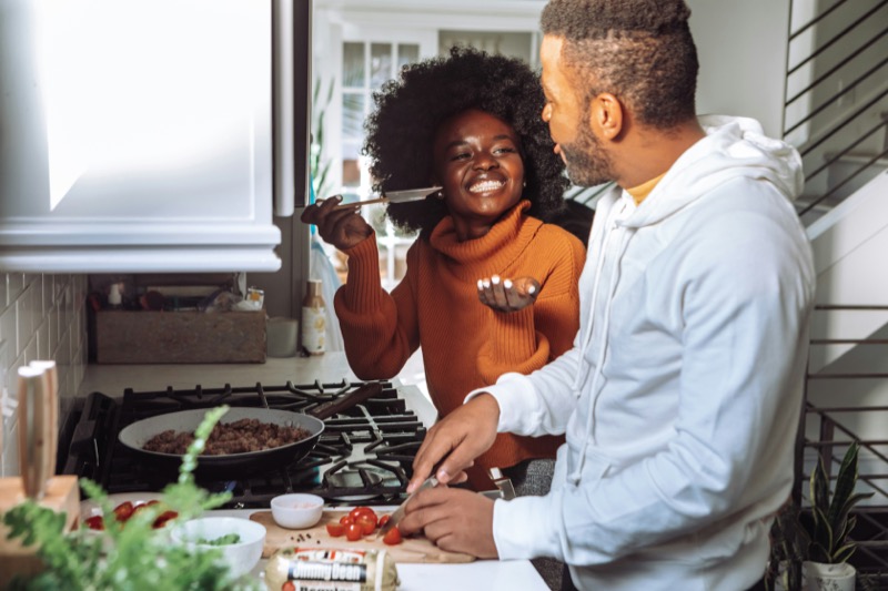 A couple cooking together at a kitchen counter