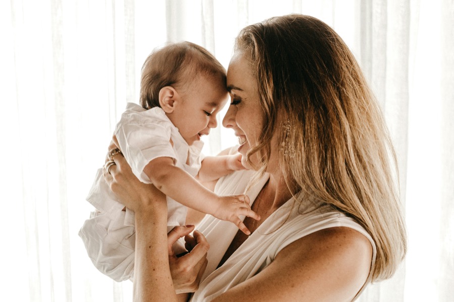 Smiling mother holding her laughing baby