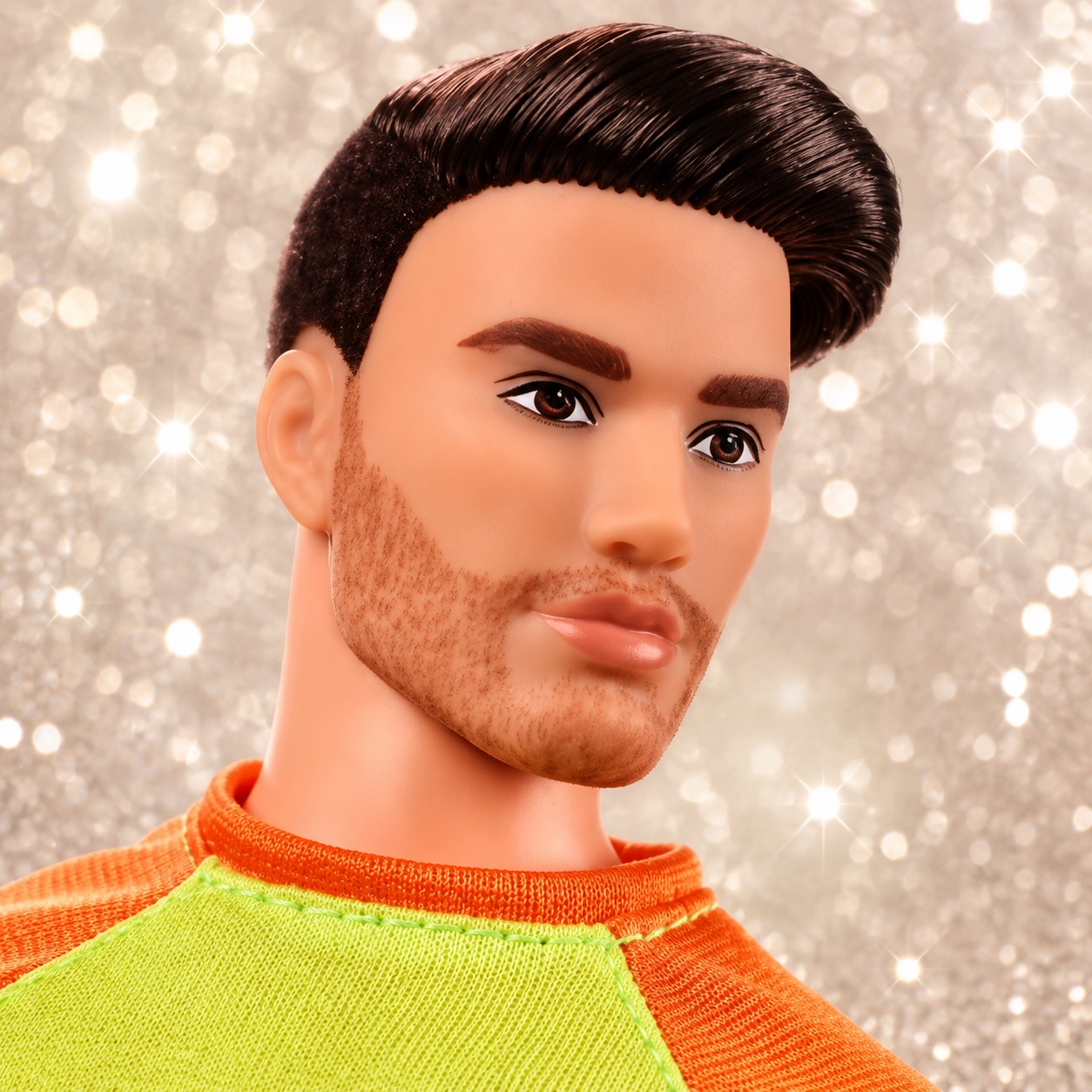 A Ken doll with a chiselled jaw and immaculate hair against a sparkly background